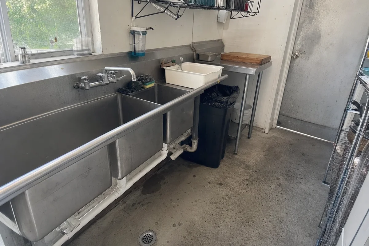Stainless prep sinks and floor drain in a small Malibu restaurant kitchen